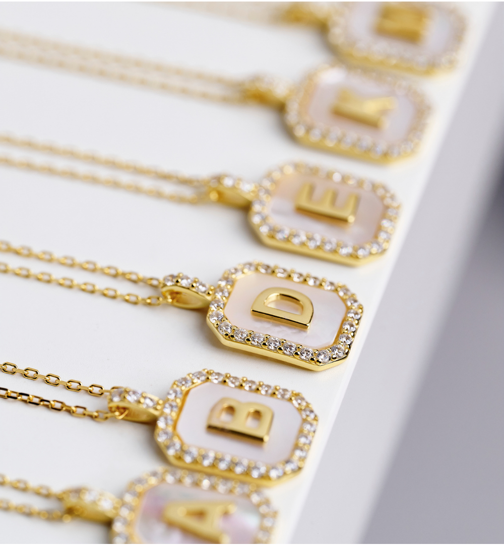 Naszyjnik z literką D na perłowym tle z cyrkoniami NCA0103