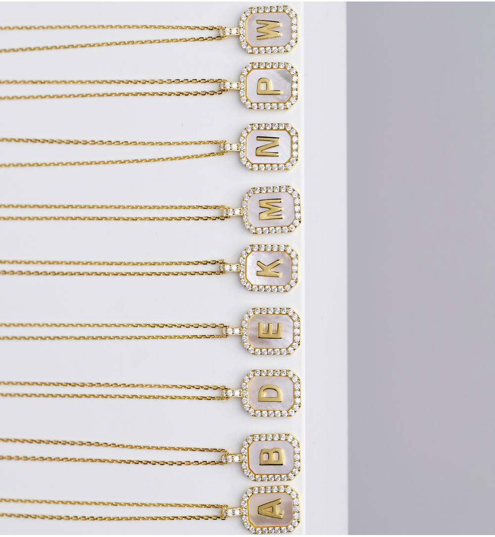 Naszyjnik z literką E na perłowym tle z cyrkoniami NCA0104