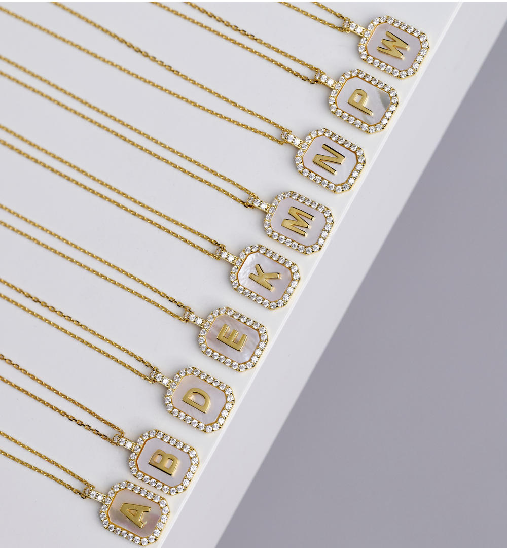 Naszyjnik z literką E na perłowym tle z cyrkoniami NCA0104